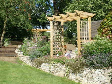 Close planted trailing rockery plants and perennials soften the dry 
