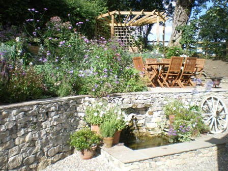 Copyright image: A wonderful corner pergola design in a romantic cottage garden.