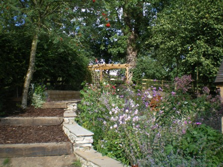 Copyright image: A wonderful corner pergola design in a romantic cottage garden.