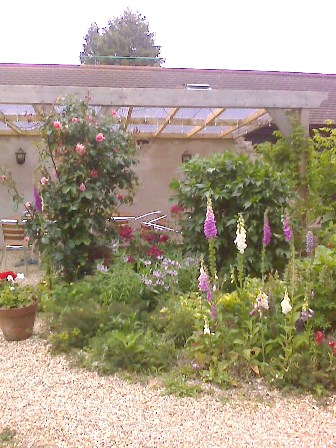 Copyright image: A fantastic attached lean-to pergola with lovely cottage garden planting.