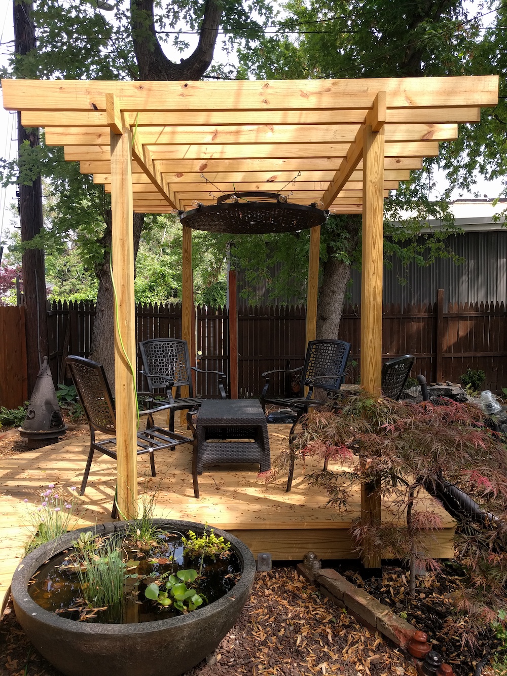 Copyright image: modern pergola with central hanging light feature.