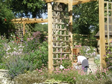 Copyright image: A pergola arch and stunning corner pergola in a wonderful cottage garden. 