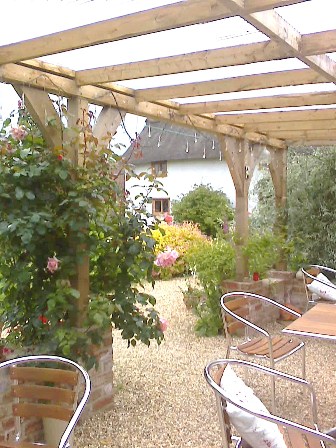 Copyright image: A fantastic attached lean-to pergola with lovely climbing roses growing up the pergola posts.