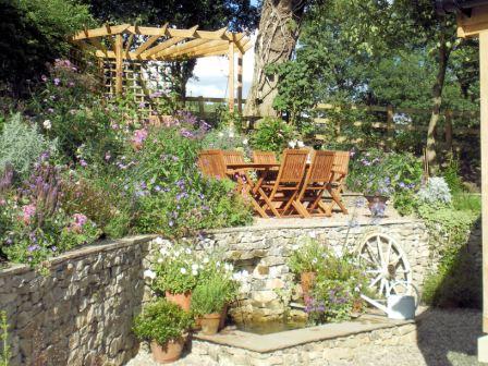 Copyright image: A wonderful corner pergola design in a romantic cottage garden.