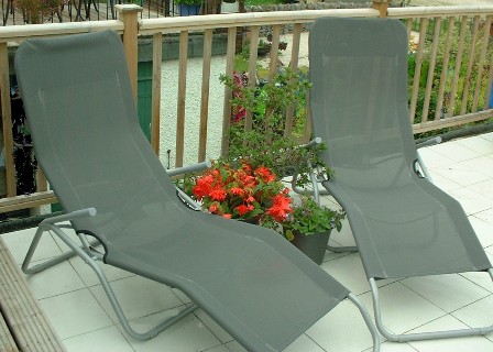 Copyright image: Sun loungers with potted plants on a roof garden.