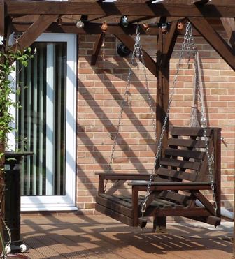 Copyright image: A fabulous attached lean-to pergola design with a swing seat.