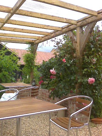 Copyright image: A fantastic attached lean-to pergola with lovely climbing roses growing up the pergola posts.